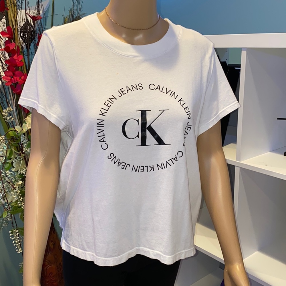 White Calvin Klein tee. Circular logo design in black.